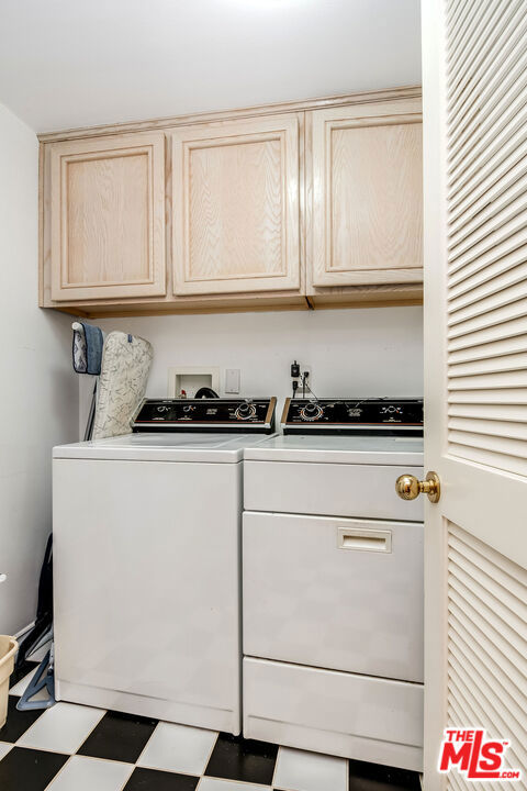 laundry room featuring cabinets and washer and clothes dryer