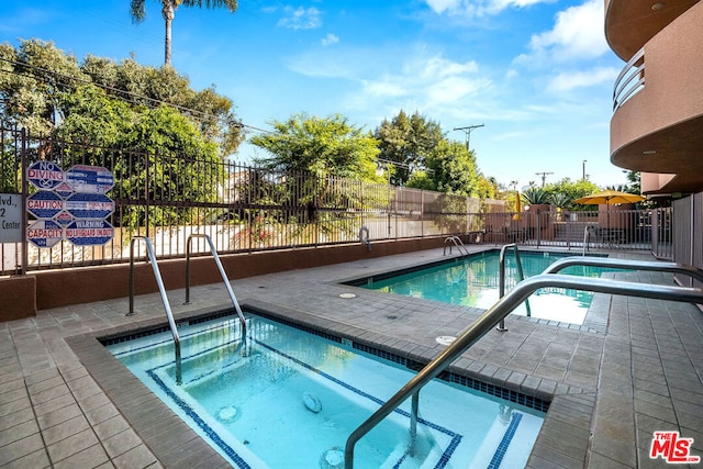 view of pool featuring a patio area and a community hot tub