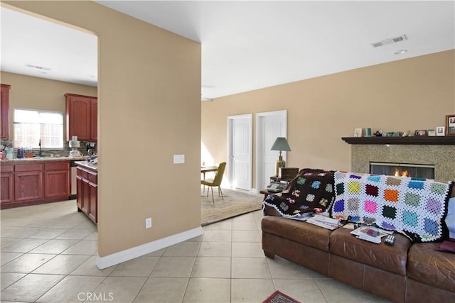 living room featuring sink and light tile patterned flooring