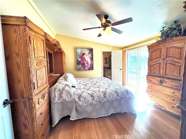 bedroom with a textured ceiling, vaulted ceiling, wood-type flooring, and ceiling fan