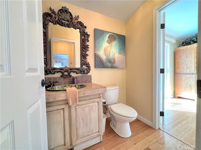 bathroom featuring toilet, hardwood / wood-style floors, and vanity