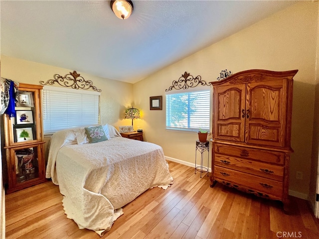 bedroom featuring vaulted ceiling and light wood-type flooring