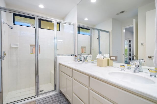 bathroom with a wealth of natural light, vanity, and walk in shower