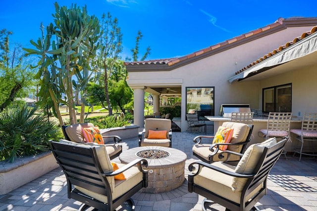 view of patio / terrace with a fire pit and exterior kitchen