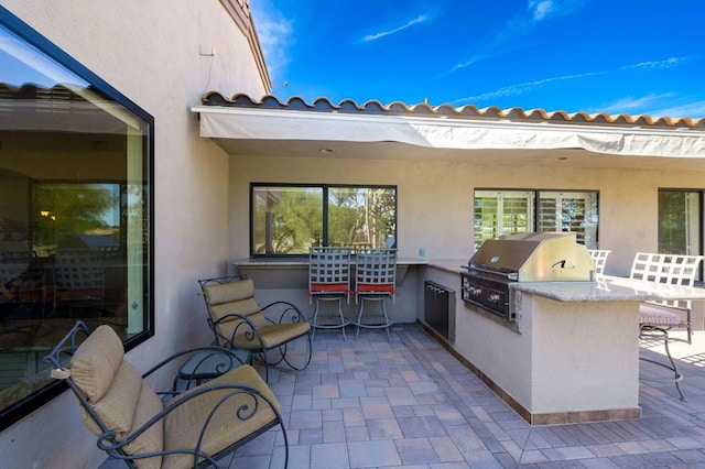 view of patio with area for grilling and a grill