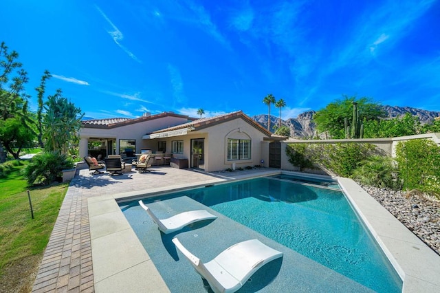 view of swimming pool with a mountain view, an outdoor living space, and a patio