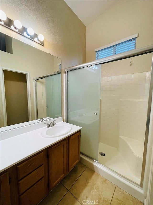 bathroom featuring tile patterned flooring, vanity, and a shower with shower door