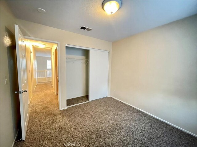 unfurnished bedroom with carpet floors and a closet