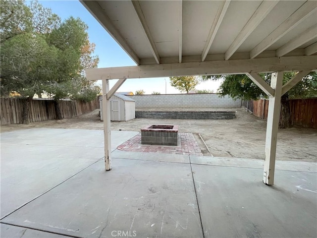 view of patio with a shed and a fire pit