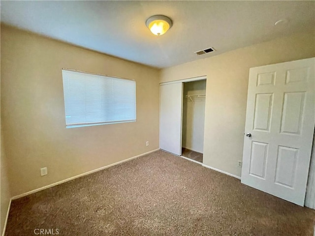 unfurnished bedroom with a closet and carpet floors