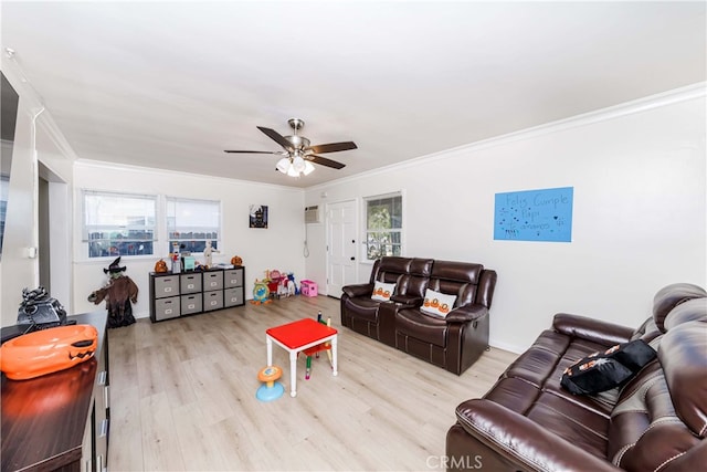 living room with ornamental molding, ceiling fan, light wood-type flooring, and plenty of natural light