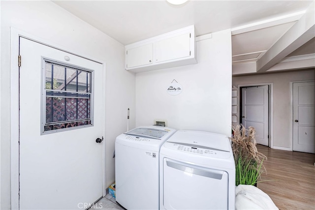 clothes washing area featuring washer and dryer and light hardwood / wood-style flooring