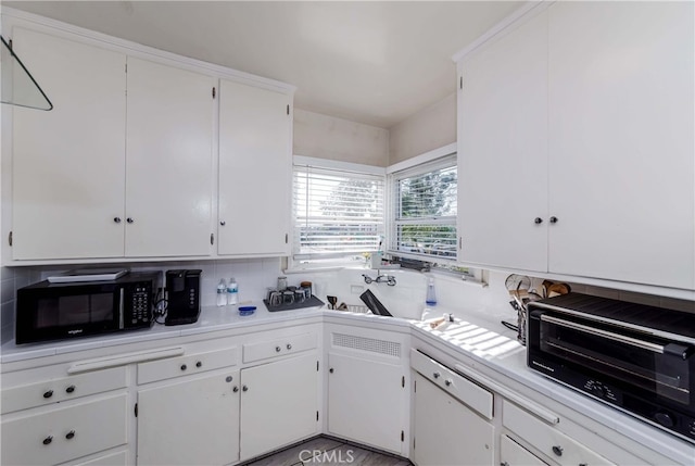 kitchen featuring white cabinetry, tasteful backsplash, and sink