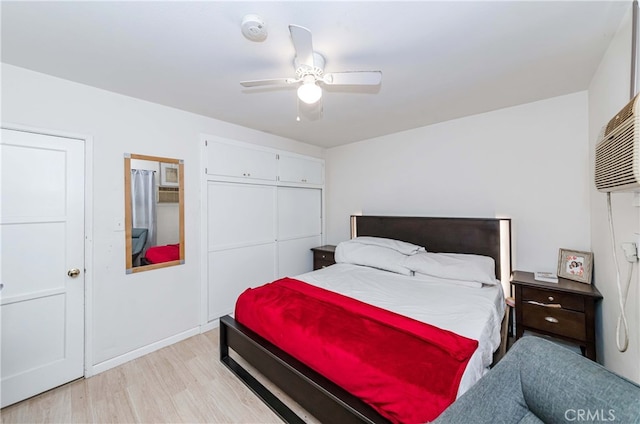 bedroom with a closet, light hardwood / wood-style floors, and ceiling fan