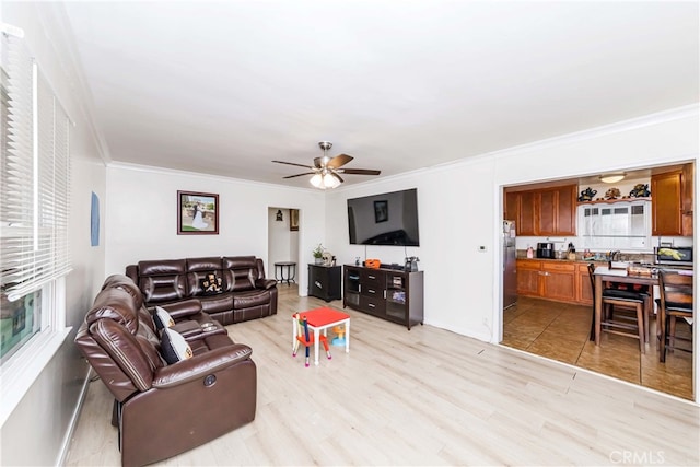 living room with light hardwood / wood-style flooring, ceiling fan, and crown molding