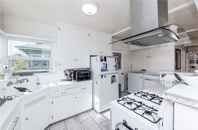 kitchen featuring extractor fan, washer and dryer, white cabinets, and white appliances