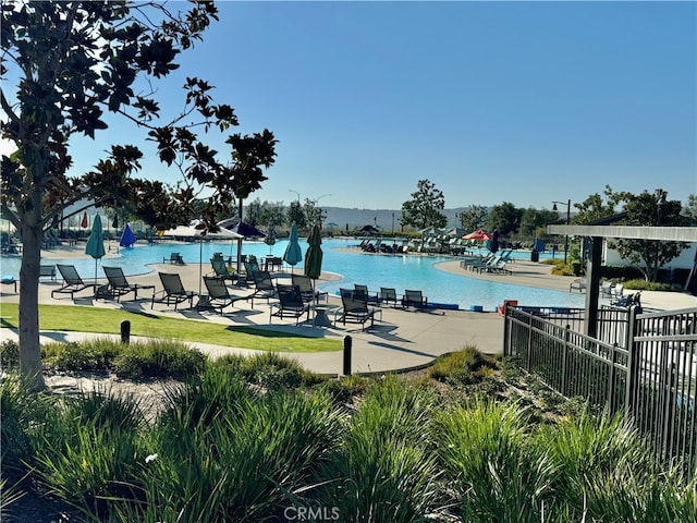 view of swimming pool with a patio and a water view