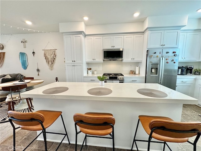 kitchen featuring a breakfast bar, a center island, stainless steel appliances, and light wood-type flooring