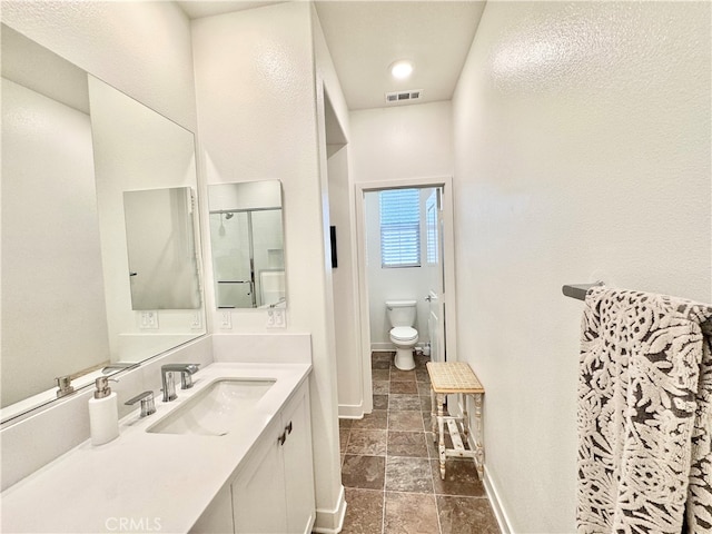 bathroom featuring vanity, toilet, and walk in shower