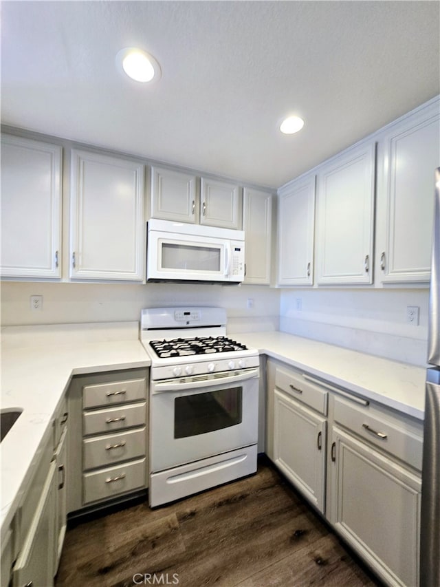 kitchen featuring white appliances, light stone counters, dark wood-type flooring, and white cabinets