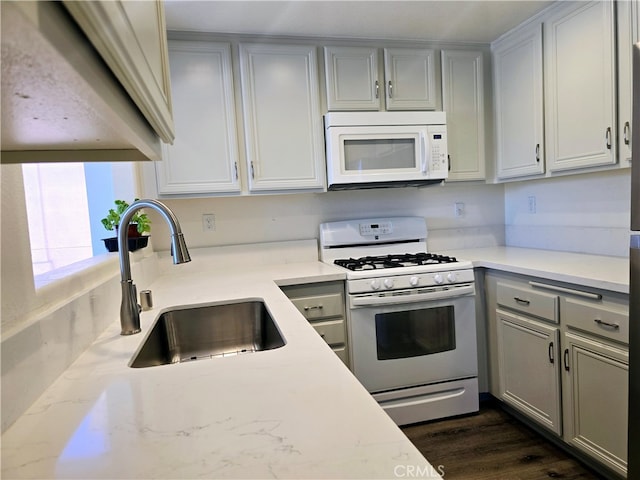 kitchen featuring white appliances, sink, gray cabinets, and dark hardwood / wood-style flooring