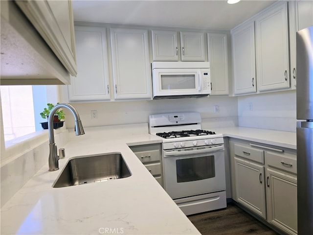 kitchen featuring dark hardwood / wood-style flooring, sink, and white appliances