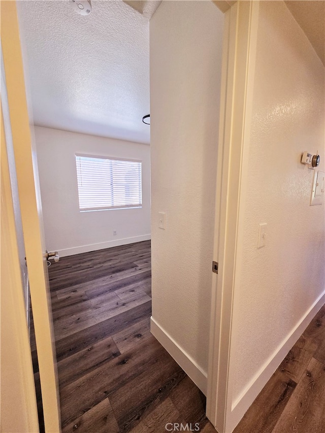 hall featuring dark hardwood / wood-style floors and a textured ceiling