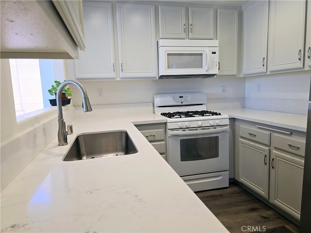 kitchen featuring light stone countertops, dark hardwood / wood-style floors, gray cabinetry, sink, and white appliances