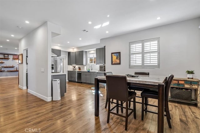 dining area with dark wood-type flooring, a wealth of natural light, and sink