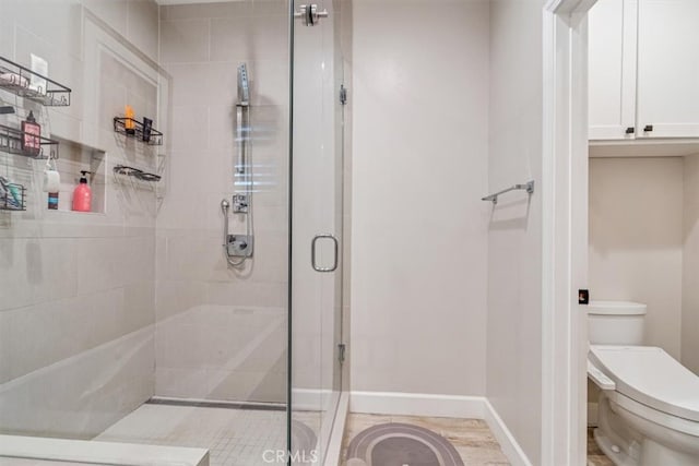 bathroom featuring toilet and an enclosed shower