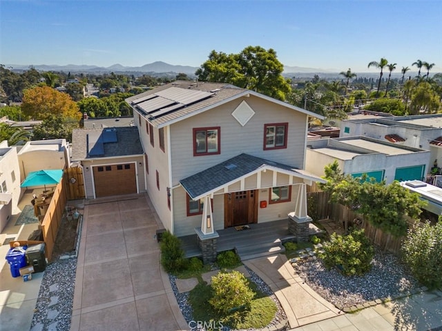 view of front of house with a mountain view, a garage, and solar panels