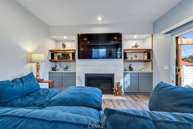 living room featuring light wood-type flooring and a fireplace