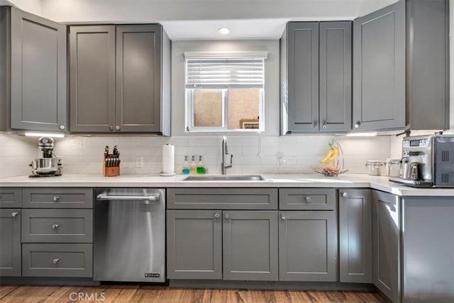 kitchen with gray cabinetry, dishwasher, and sink