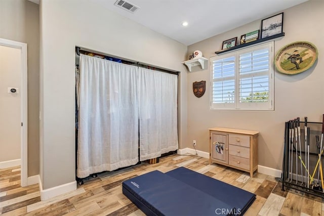 workout area with light hardwood / wood-style flooring