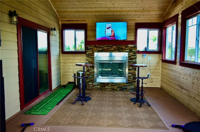 exercise area with carpet floors, lofted ceiling, and a fireplace