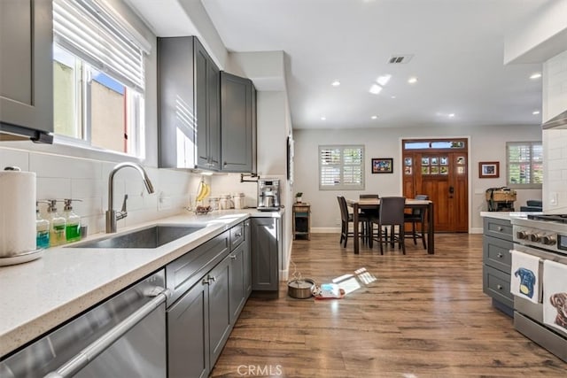 kitchen featuring decorative backsplash, appliances with stainless steel finishes, sink, and gray cabinetry