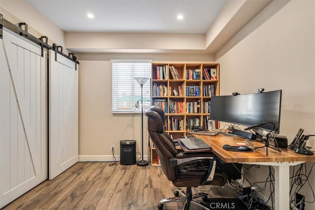 home office featuring a barn door and wood-type flooring