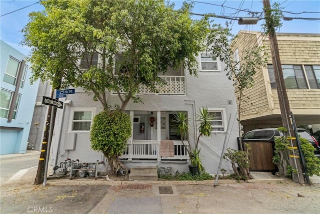 view of property with covered porch and stucco siding