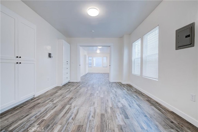 interior space with electric panel and light hardwood / wood-style flooring