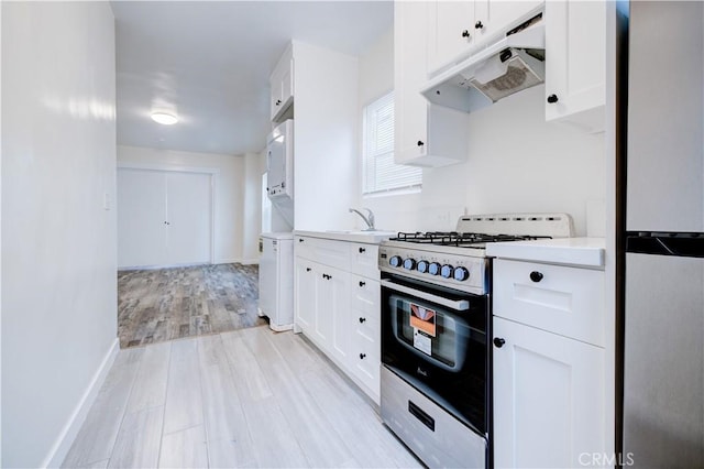 kitchen featuring white cabinetry, sink, light hardwood / wood-style flooring, and stainless steel appliances