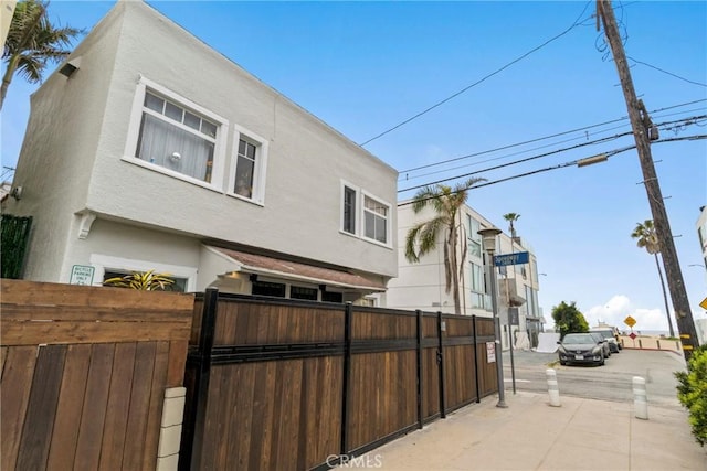 exterior space with stucco siding and fence