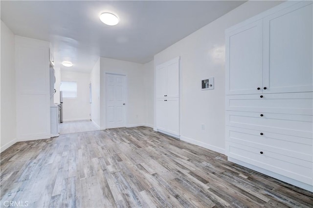 unfurnished room featuring light wood-type flooring and baseboards