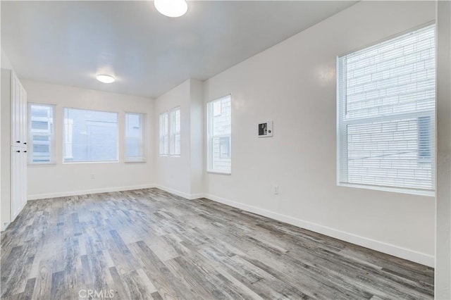 empty room featuring baseboards and wood finished floors
