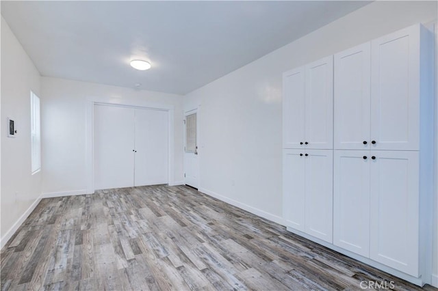 unfurnished bedroom featuring baseboards and wood finished floors