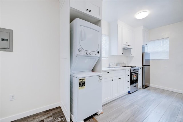 12 25th Pl, Venice, CA 90291 - laundry area featuring stacked washer / dryer, light wood-type flooring, baseboards, and healthy amount of natural light