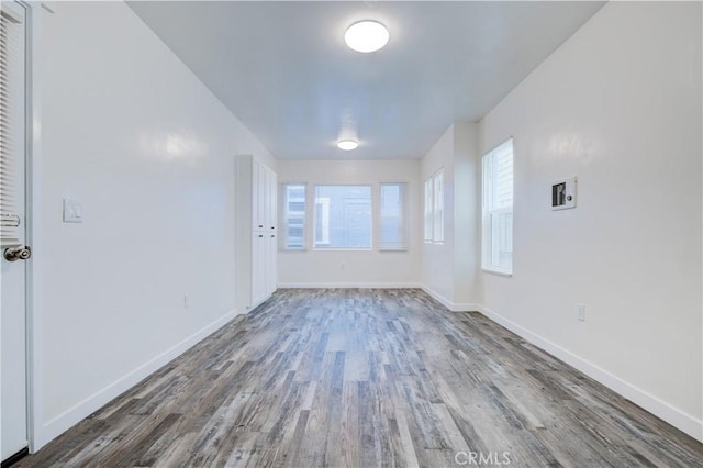 unfurnished room with baseboards and wood finished floors