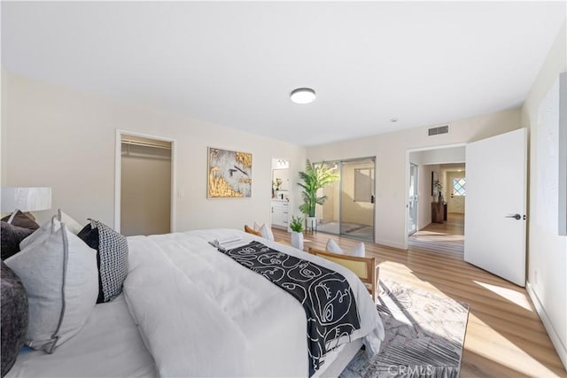 bedroom featuring a spacious closet, a closet, and light hardwood / wood-style floors