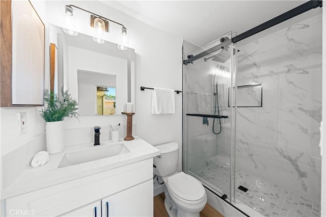 bathroom featuring wood-type flooring, vanity, toilet, and a shower with door