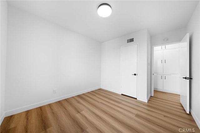 unfurnished bedroom featuring light wood-type flooring and a closet