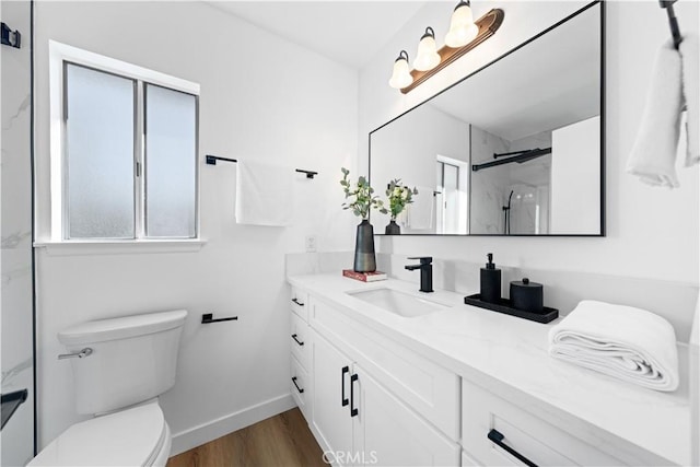 bathroom featuring hardwood / wood-style floors, vanity, a shower with shower door, and toilet